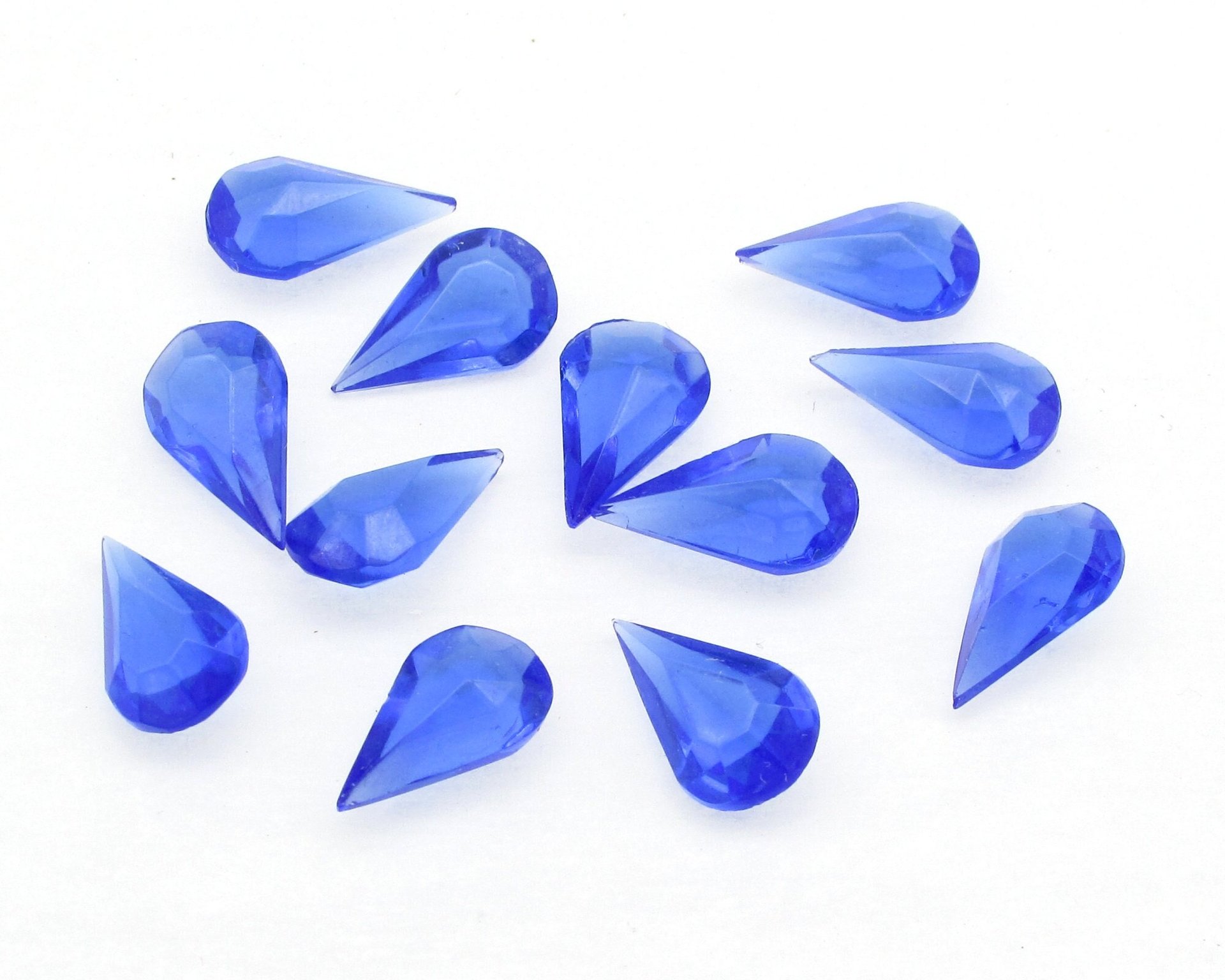 Vintage tin table cut pear shape rhinestones are translucent sapphire blue. Unfoiled point back stones measure 13mm long and 7.8mm wide.