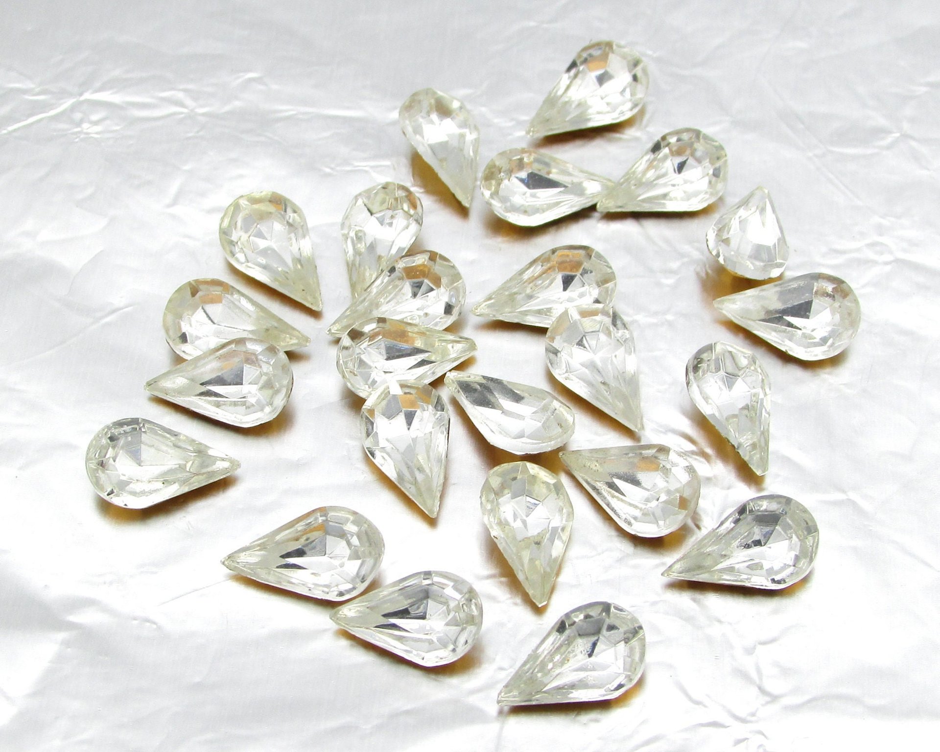 Vintage tin table cut pear shape rhinestones are clear crystal backed with gold foil. Point back stones measure 10mm long and 6mm wide.