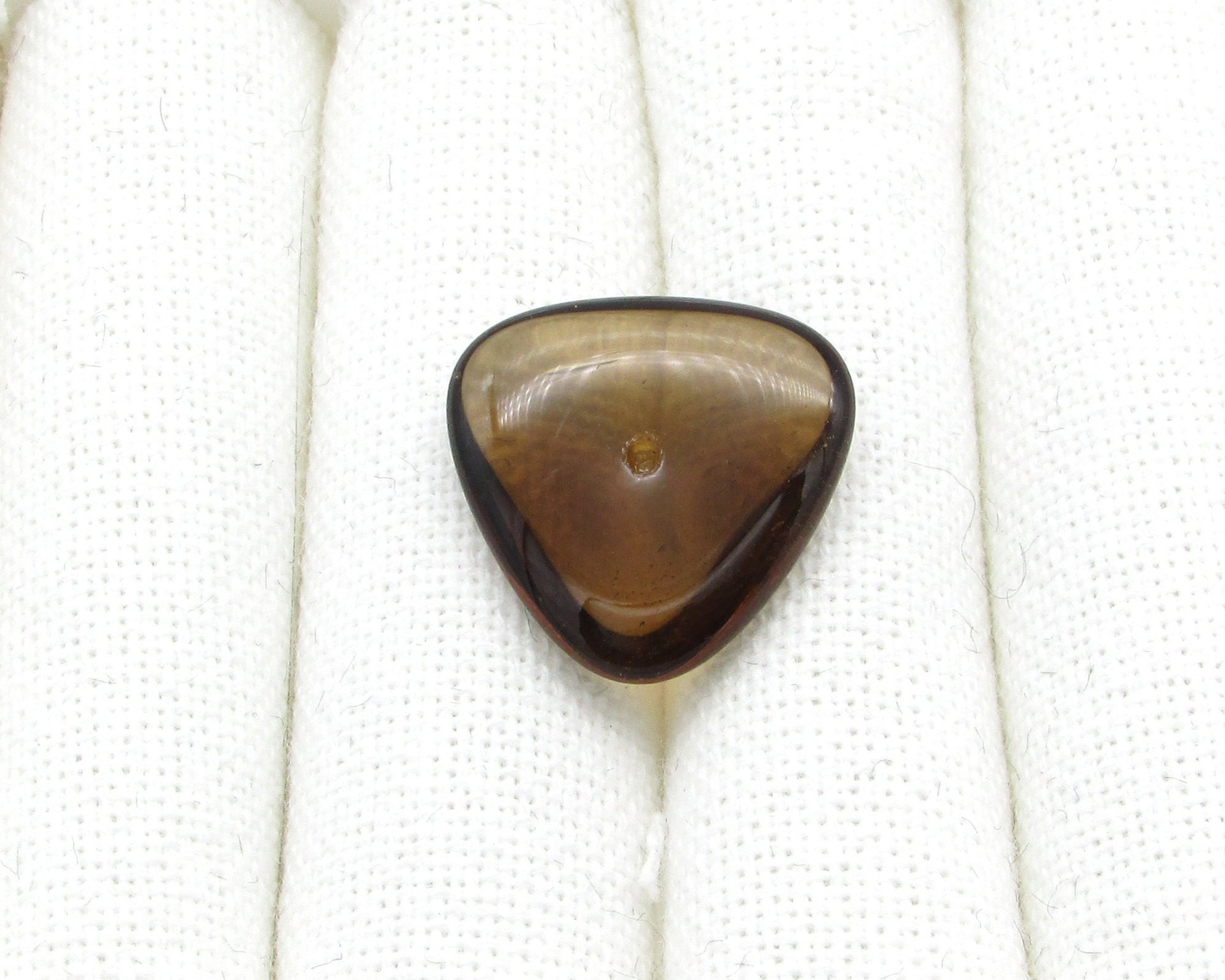 Translucent dark brown glass gem is a triangular point-back cabochon measuring 22.5mm on each side and approximately 7mm thick at the center. There is an empty round setting hole for a PP24 rhinestone is positioned in the center of the top table. 