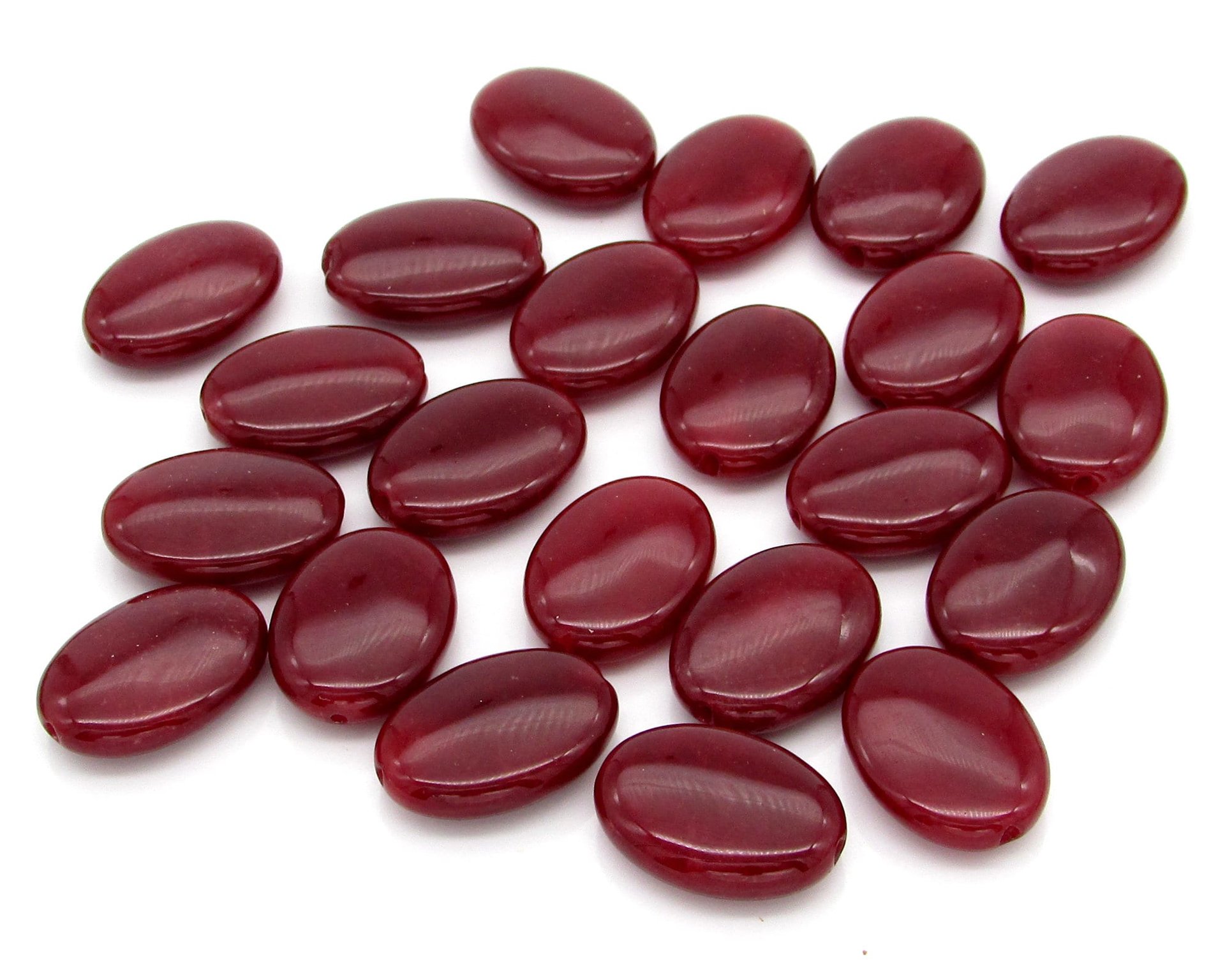 Chalcedony beads have been been dyed shades of dark red. Bead are smooth ovals measuring approximately 18mm long, 13mm wide, and 5mm thick at the center. There's a shallow notch at each each end, where the 0.8mm diameter hole is positioned.
