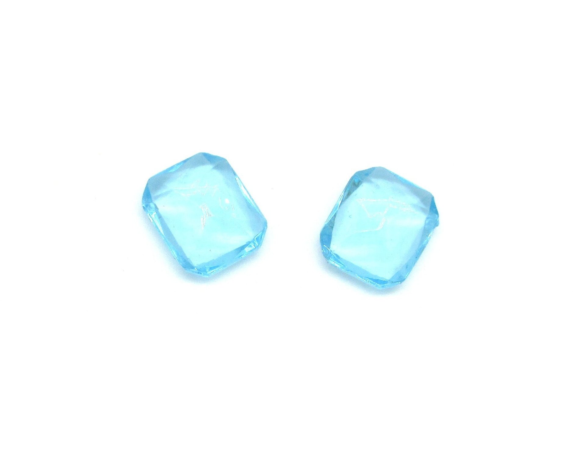 Vintage octagon rhinestones are translucent aqua with pointed, unfoiled backs. Stones measure 12mm long, 11mm wide, and 5mm thick at the center. 