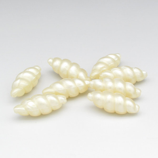 Vintage cream-colored faux pearls are tapered ovals shaped like whorled seashells. These long plastic beads measure 32mm long by 13mm wide, with 1.5mm lengthwise holes.